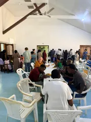 Church members sharing a meal together at long tables in the church hall